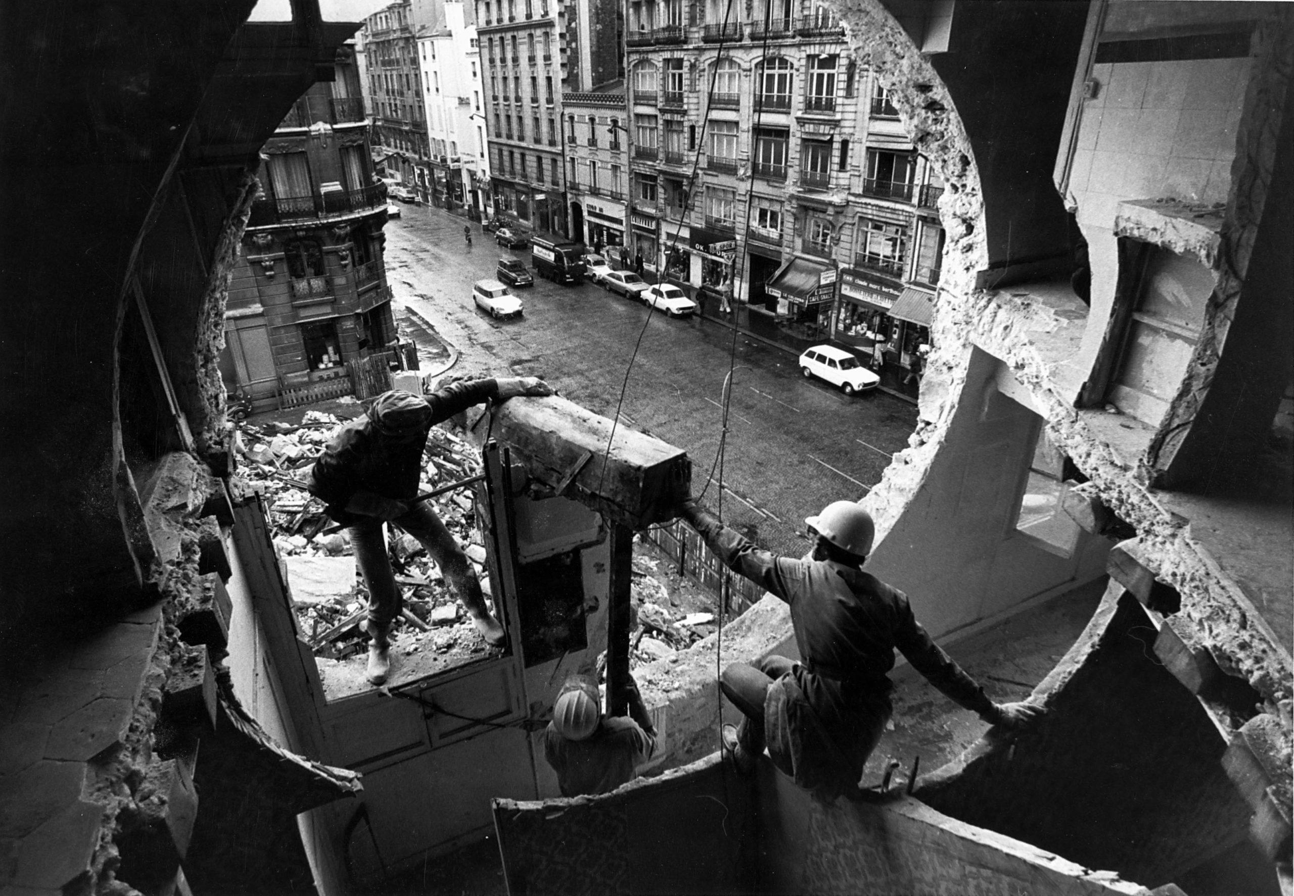 A photograph of Gordon Matta-Clark and Gerry Hovagimyan working on Conical Intersect, by Harry Gruyart, dated 1975.